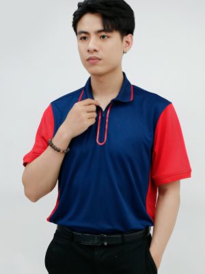 Người mẫu nam mặc áo polo đồng phục cổ khóa kéo phối màu xanh navy và đỏ, dáng đứng chính diện, form chuẩn và chuyên nghiệp.