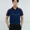 Nam người mẫu mặc áo thun đồng phục màu xanh navy phối đỏ tay raglan, phối cổ đen, thiết kế thời trang hiện đại.